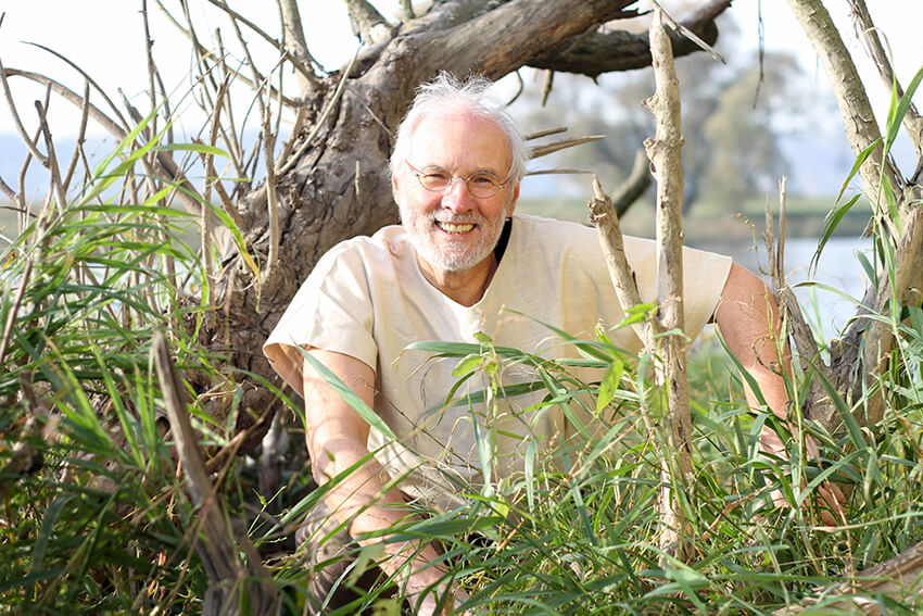Steffen zimmer kniend im Wyda-Gewand vor einem knorrigen Baum